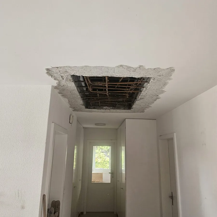 Geöffnete Betondecke mit sichtbarer Bewehrung