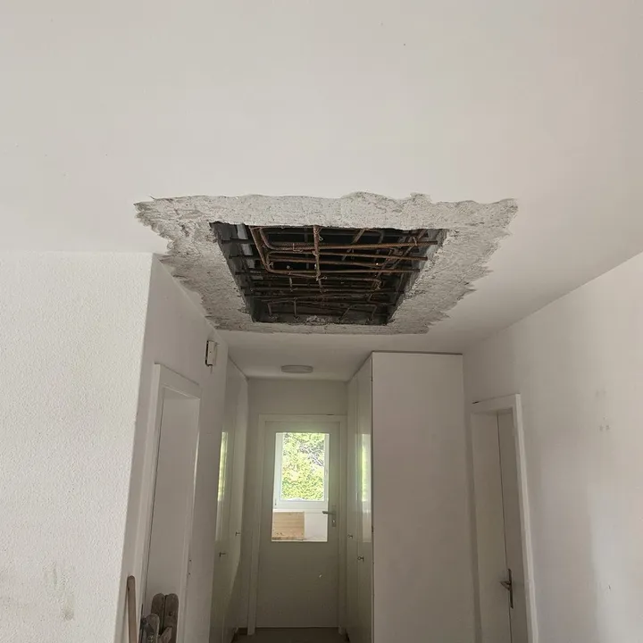 Geöffnete Betondecke mit sichtbarer Bewehrung