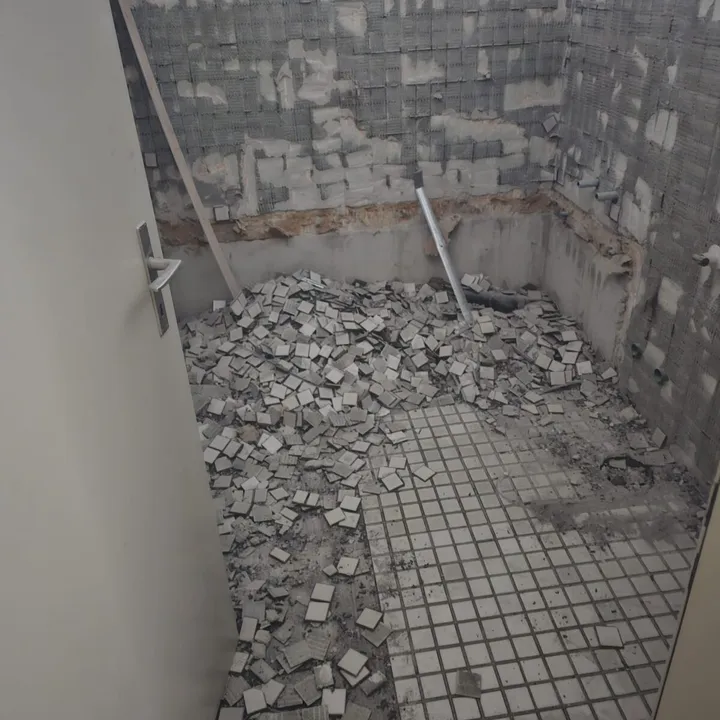 Alter Fliesenboden einer Dusche beim Rückbau