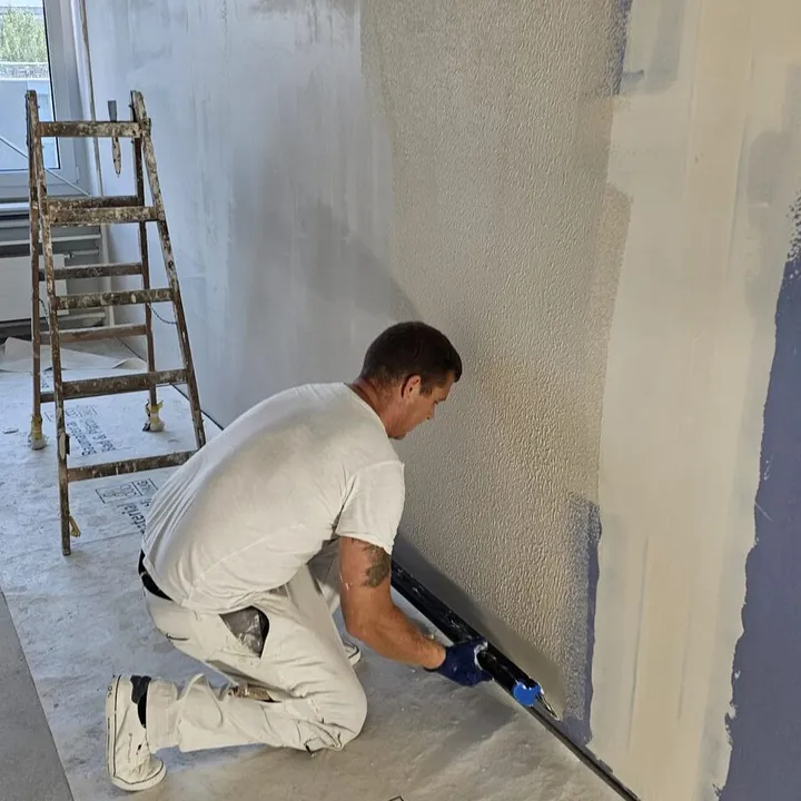 Gipser beim Verputzen einer Innenwand